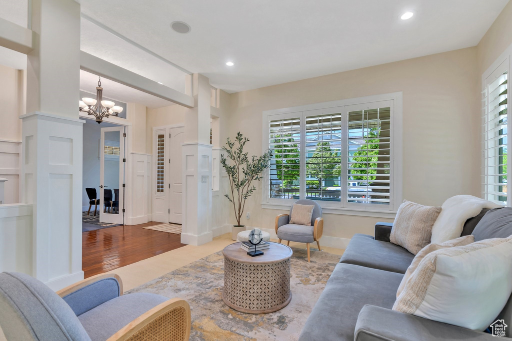 Living room featuring a chandelier, recessed lighting, wood finished floors, and baseboards