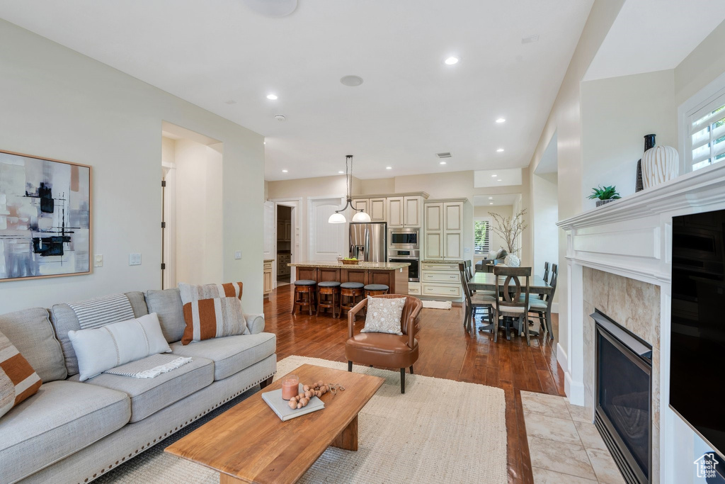 Living room with light wood finished floors, recessed lighting, and a fireplace