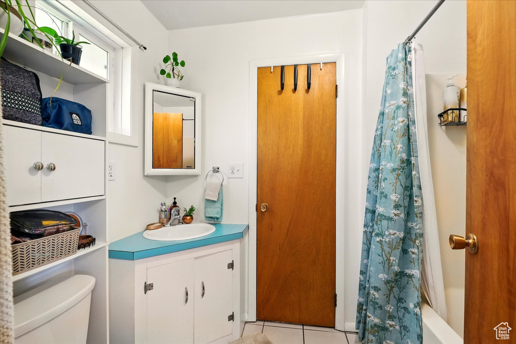 Full bath with tile patterned flooring, toilet, vanity, and shower / bathtub combination with curtain