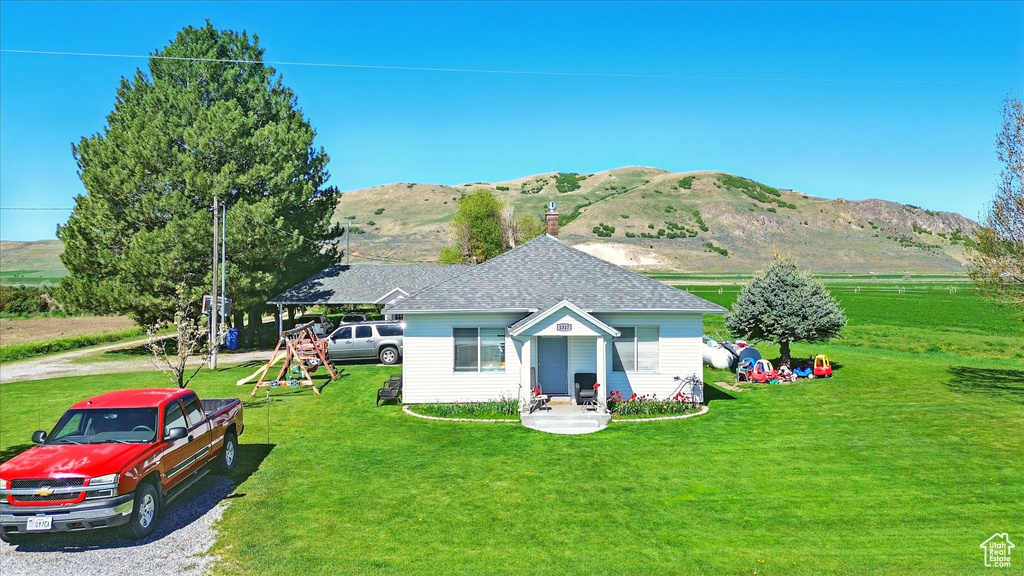 View of front of home featuring a mountain view and a front yard