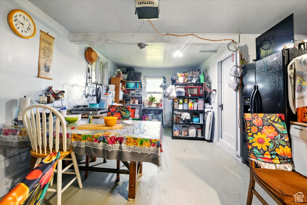 Below grade area with black fridge with ice dispenser