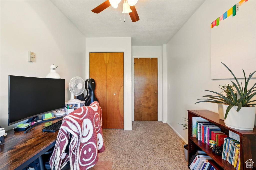 Office area with carpet floors, ceiling fan, and baseboards