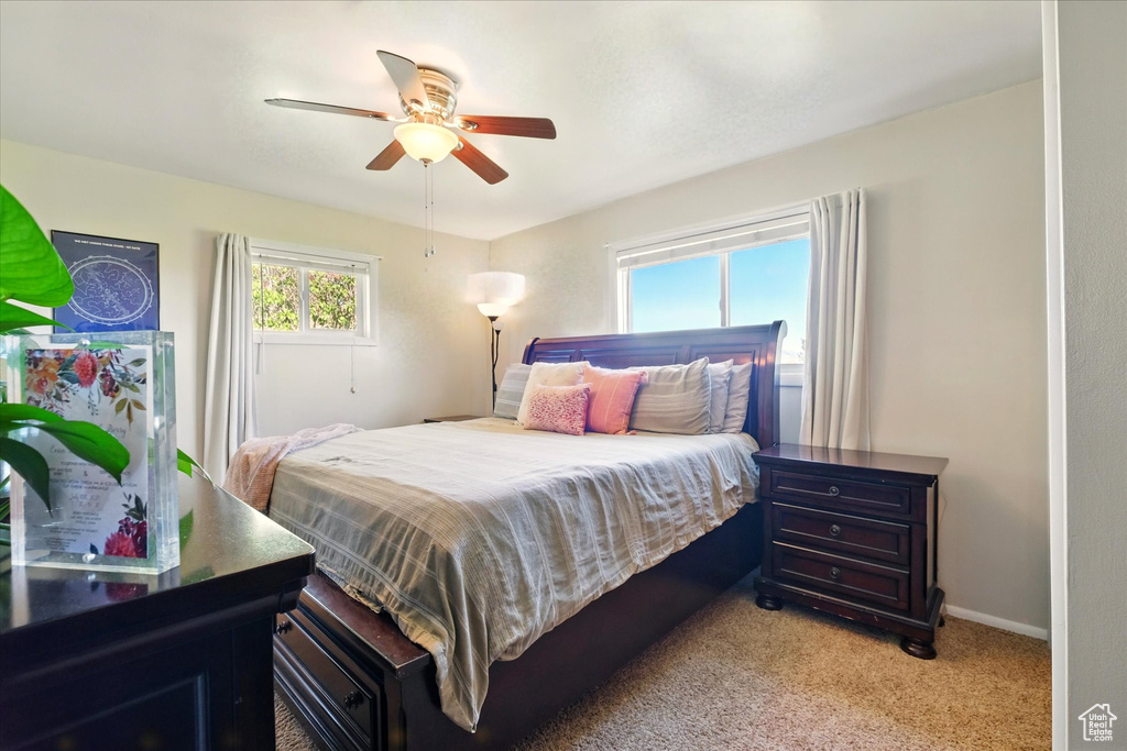 Bedroom with light carpet, baseboards, and ceiling fan