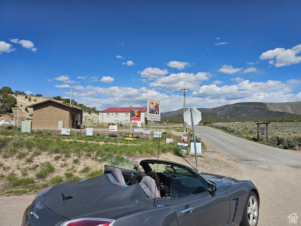 View of asphalt street featuring traffic signs and a mountain view