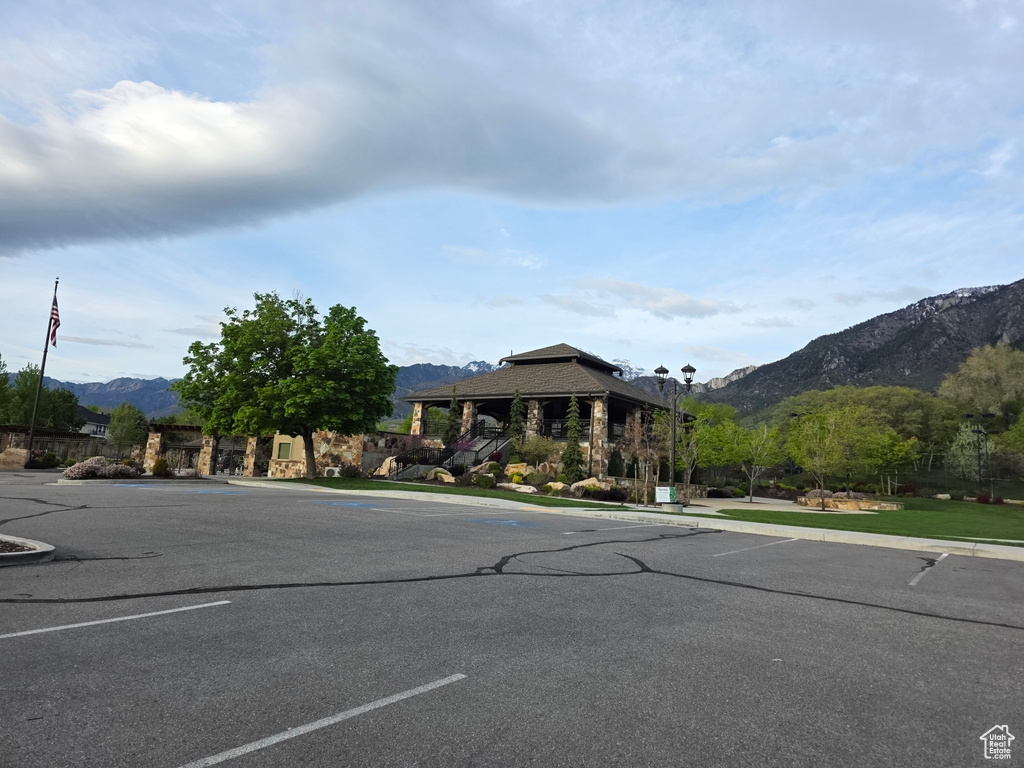 View of asphalt street featuring a mountain view, curbs, and street lighting