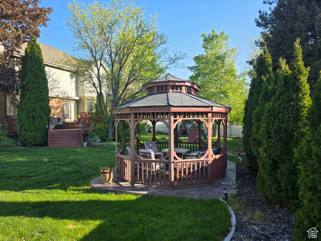 View of grassy yard featuring a gazebo and a wooden deck