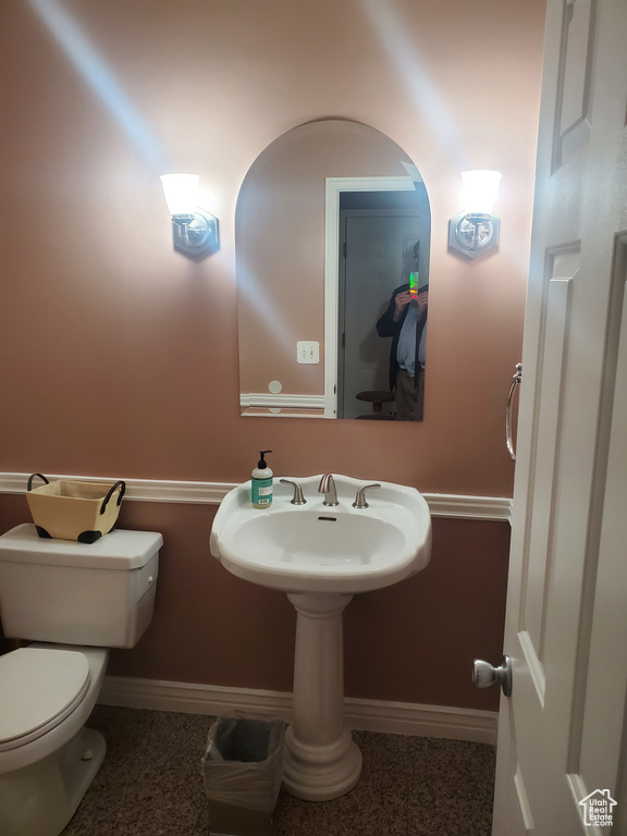 Half bathroom with baseboards and toilet