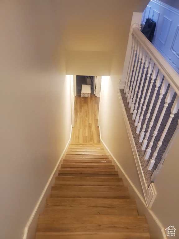 Staircase featuring wood finished floors
