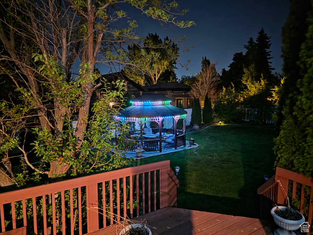Deck at night with a lawn and a gazebo