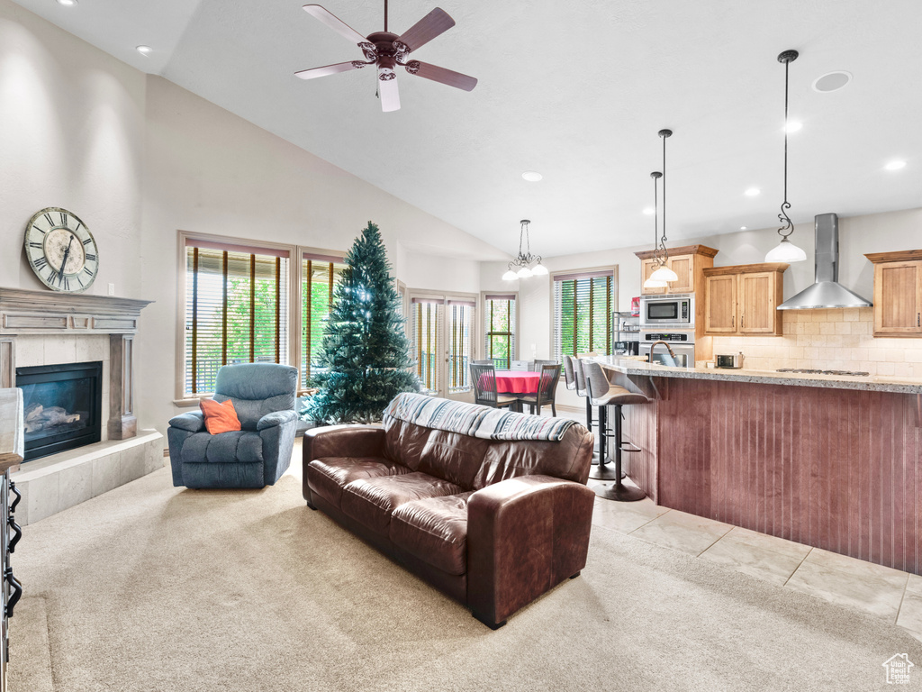 Living room featuring carpet, recessed lighting, a ceiling fan, a tile fireplace, and high vaulted ceiling