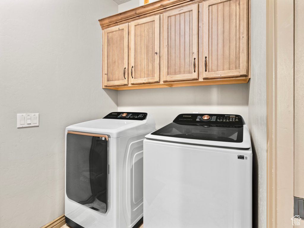 Laundry room with washing machine and clothes dryer and cabinet space
