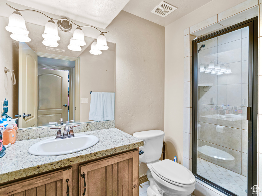 Full bath with toilet, a shower stall, and vanity