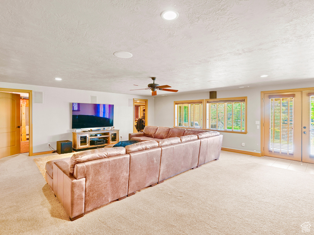 Living area featuring light carpet, baseboards, a textured ceiling, a ceiling fan, and recessed lighting