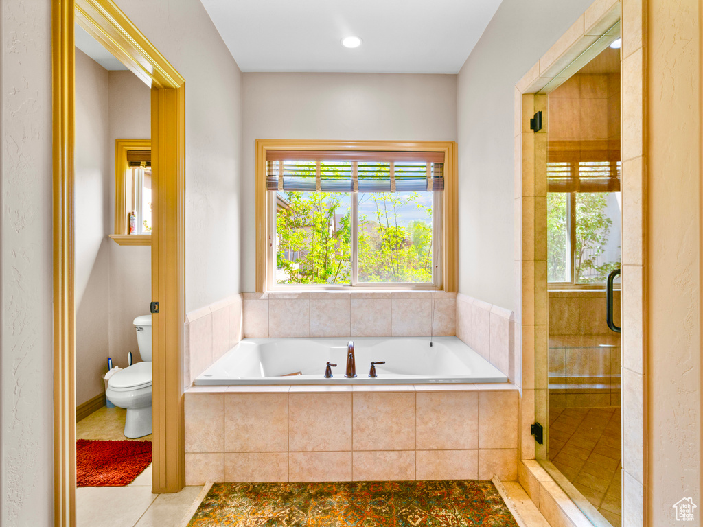 Bathroom featuring a bath, toilet, tile patterned floors, and a shower stall
