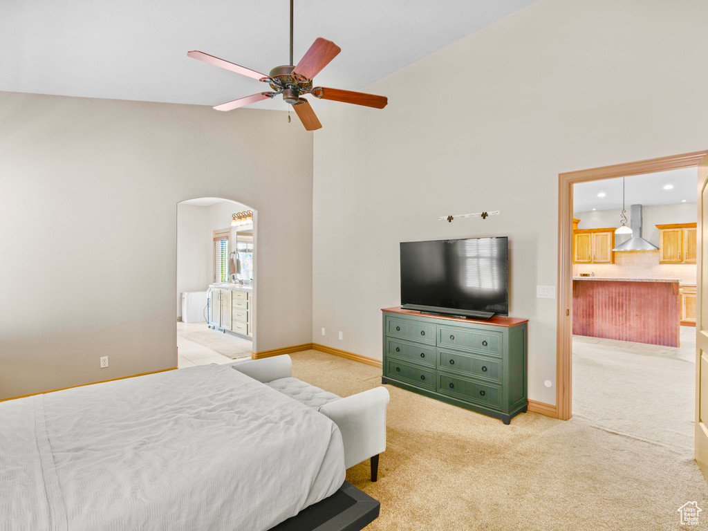 Bedroom with arched walkways, high vaulted ceiling, light carpet, baseboards, and recessed lighting