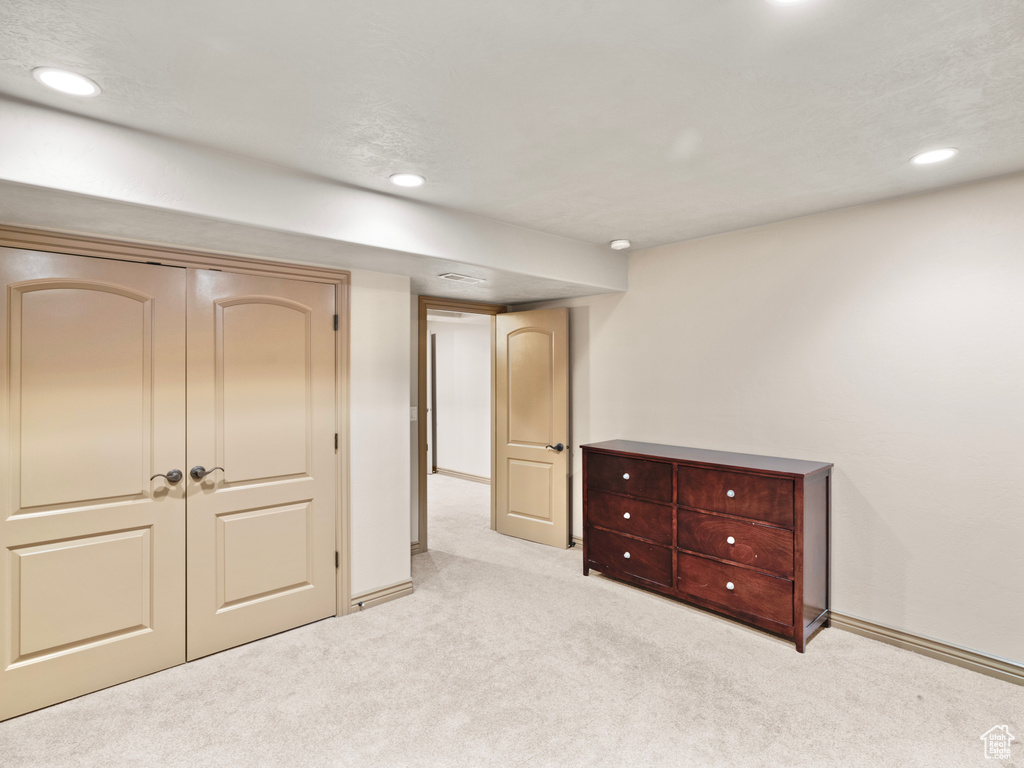 Carpeted bedroom featuring recessed lighting, baseboards, and a closet