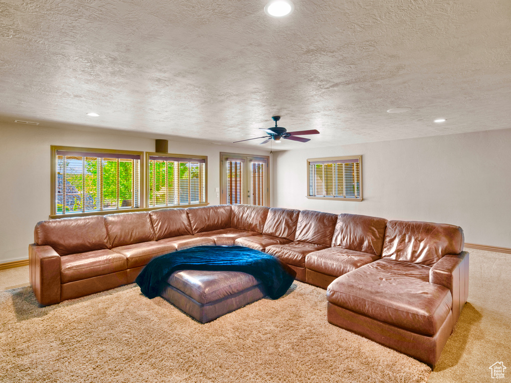 Carpeted living area with ceiling fan, a textured ceiling, recessed lighting, and baseboards