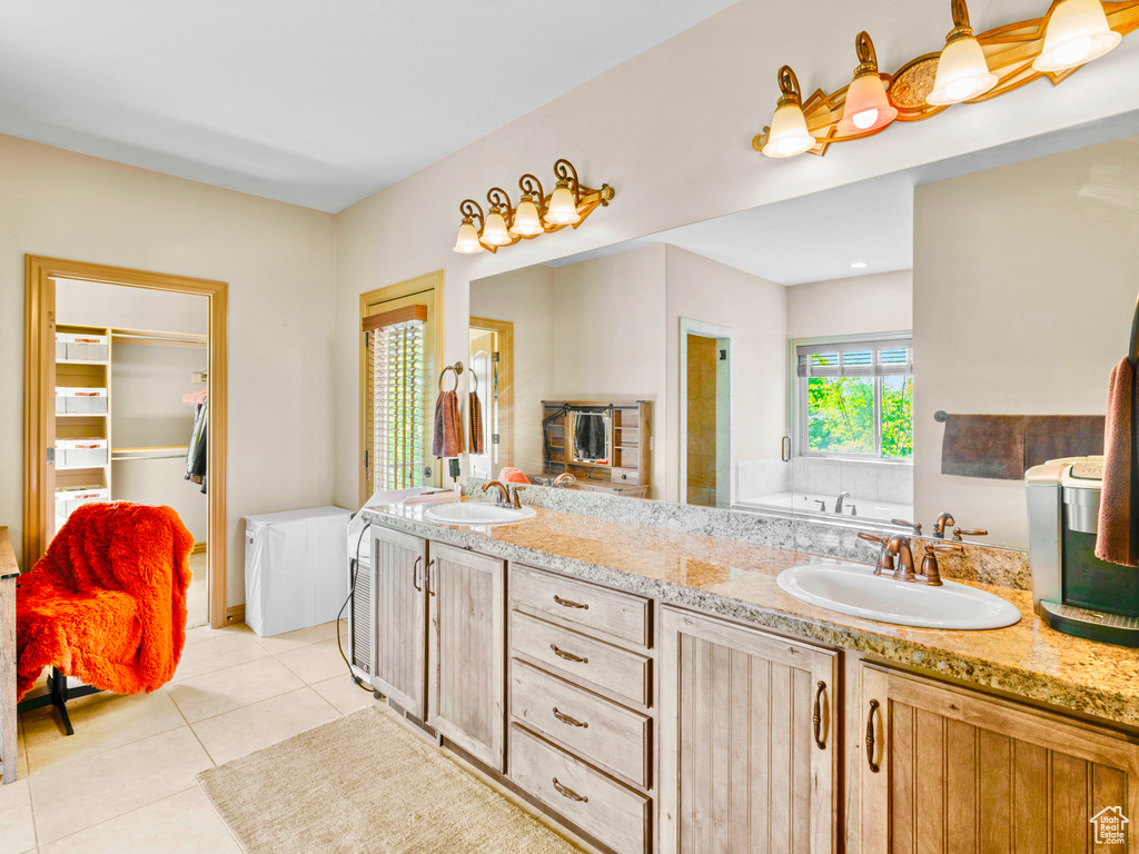 Full bath featuring tile patterned floors, double vanity, and a garden tub
