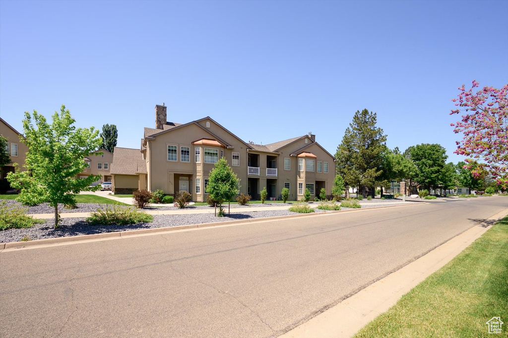 View of front facade with stucco siding and a chimney