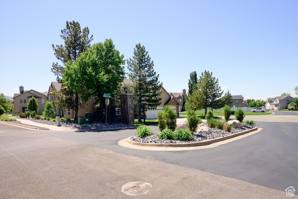 View of asphalt street featuring a residential view and curbs