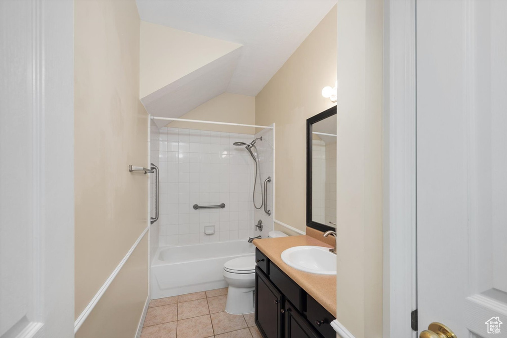 Full bath featuring vanity, toilet, tile patterned floors, shower / tub combination, and lofted ceiling