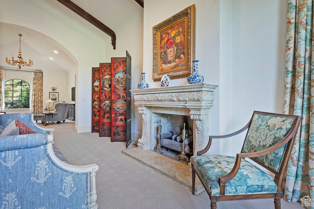 Living area featuring carpet flooring, arched walkways, a chandelier, and baseboards