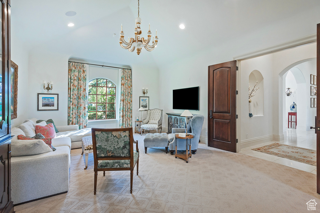 Living room with a chandelier, arched walkways, high vaulted ceiling, recessed lighting, and baseboards