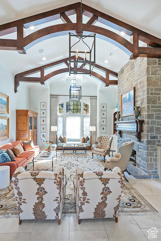 Living room with a chandelier, a stone fireplace, recessed lighting, and arched walkways