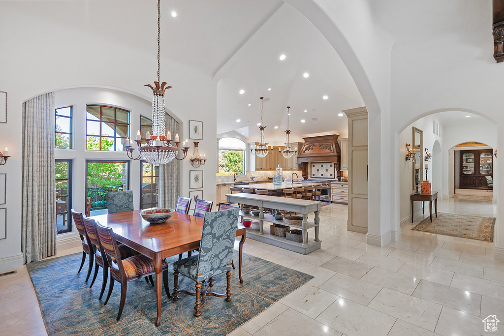 Dining area featuring high vaulted ceiling, a chandelier, recessed lighting, and arched walkways
