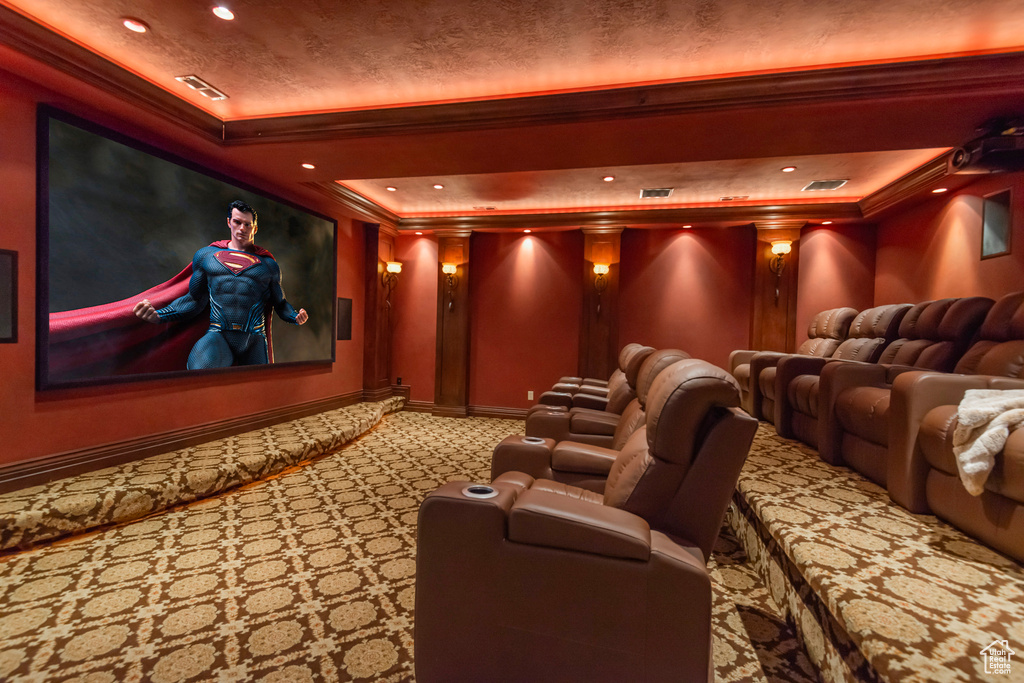 Cinema room with crown molding, a tray ceiling, carpet floors, recessed lighting, and baseboards