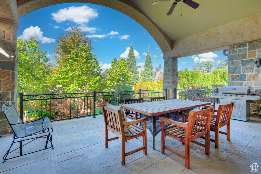 View of patio with grilling area, a ceiling fan, and outdoor dining space