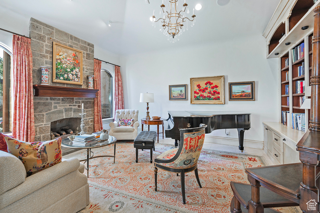 Living room featuring baseboards, a stone fireplace, and a chandelier