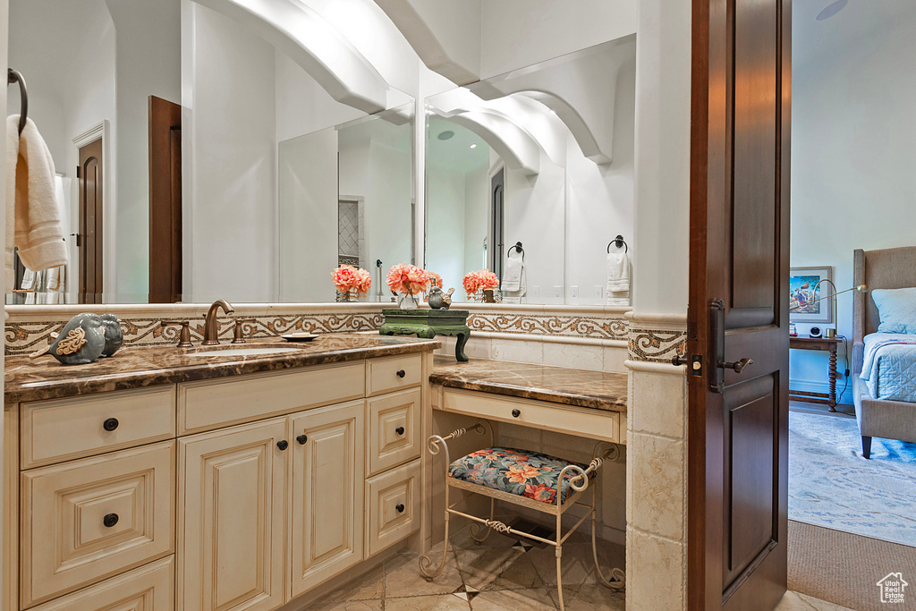 Ensuite bathroom with vanity and tile patterned flooring