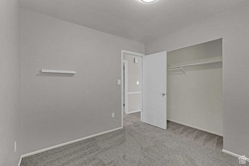 Unfurnished bedroom with carpet flooring, baseboards, and a closet