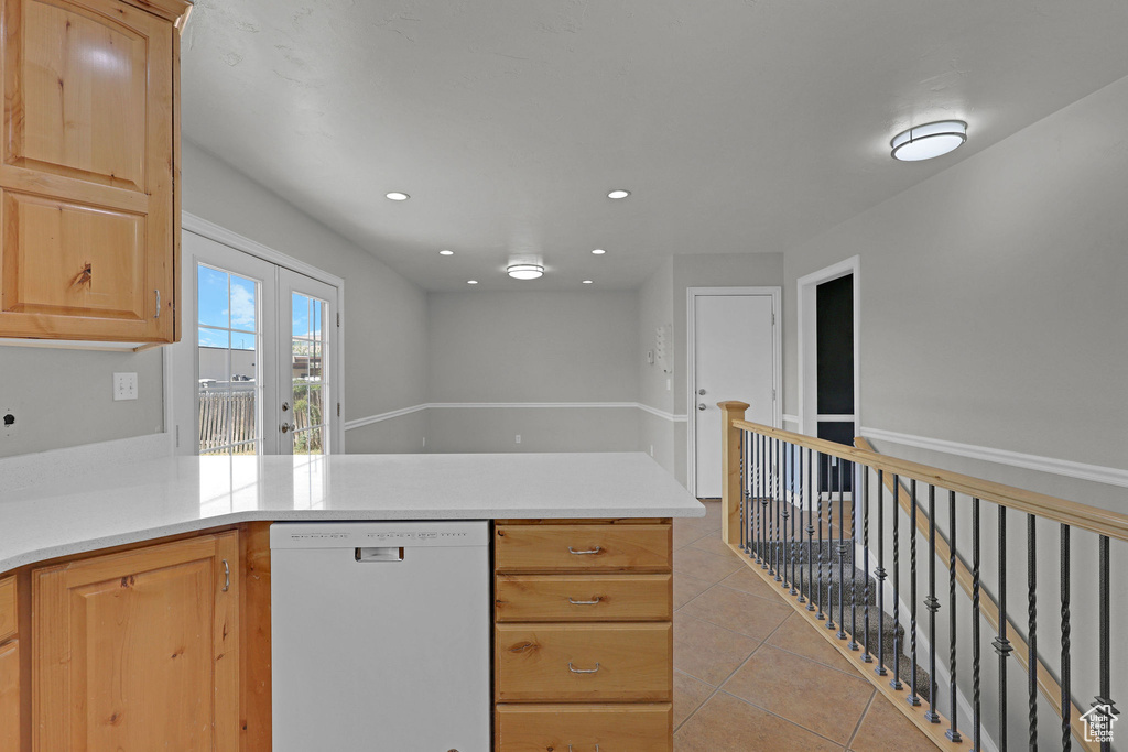 Kitchen featuring dishwasher, a peninsula, light tile patterned flooring, light countertops, and recessed lighting