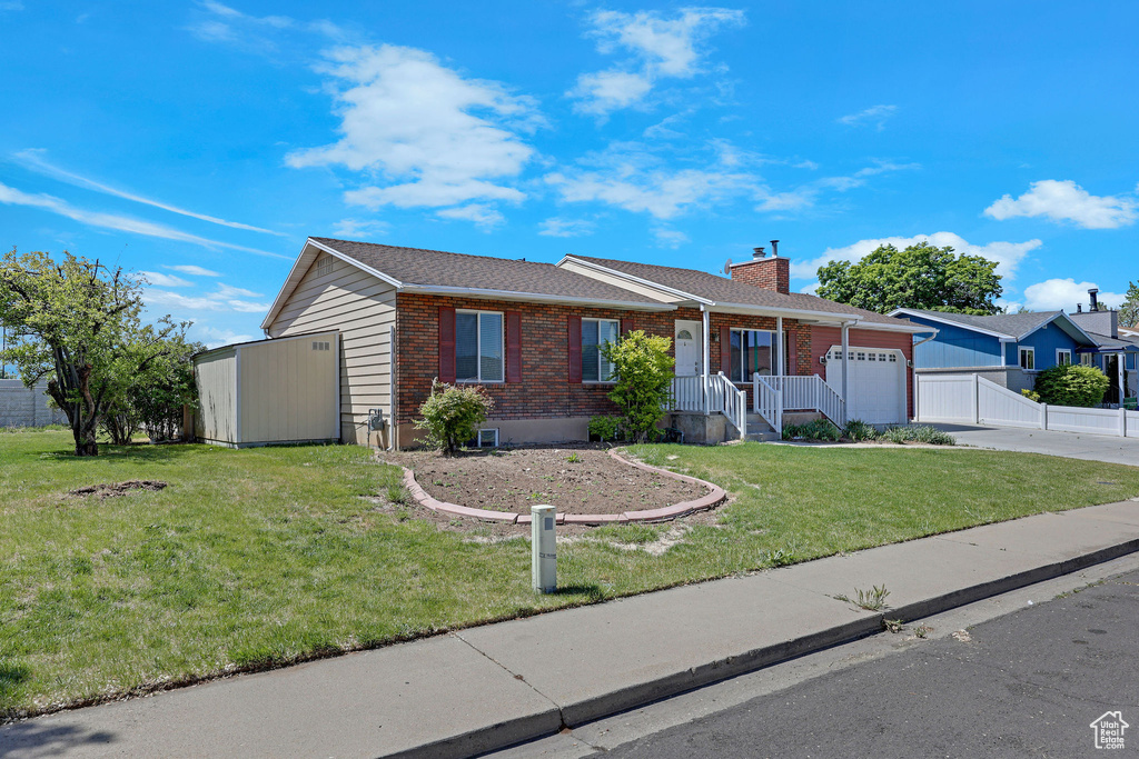 Ranch-style home with brick siding, an attached garage, concrete driveway, and a chimney