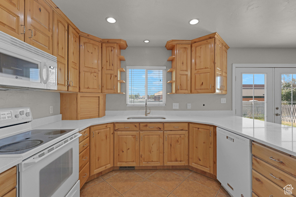 Kitchen featuring white appliances, a sink, open shelves, light countertops, and recessed lighting