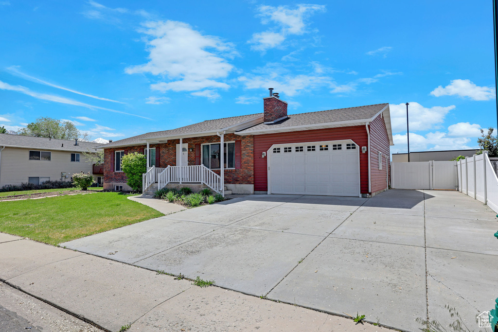 Single story home featuring a garage, brick siding, driveway, a chimney, and a shingled roof