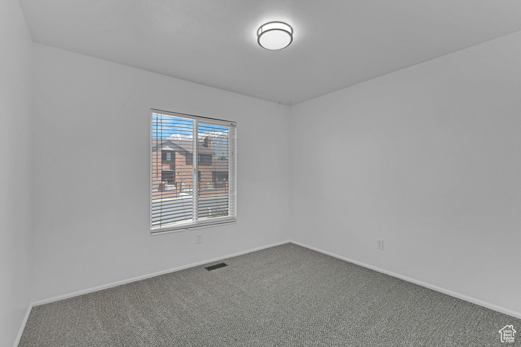 Unfurnished room featuring carpet floors and baseboards