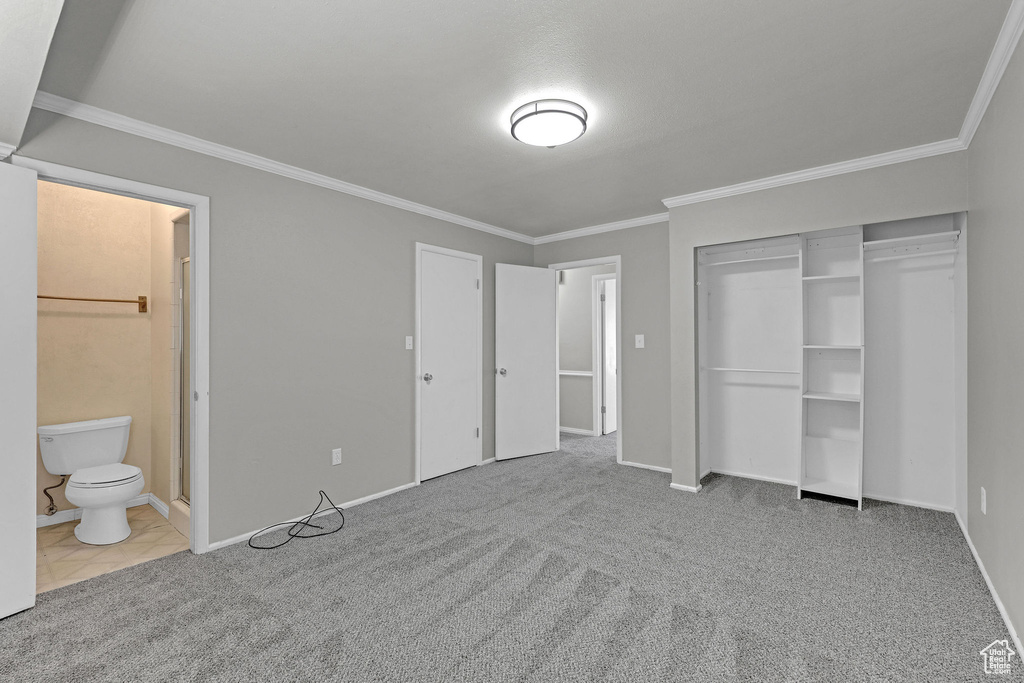Unfurnished bedroom with crown molding, carpet floors, connected bathroom, and baseboards