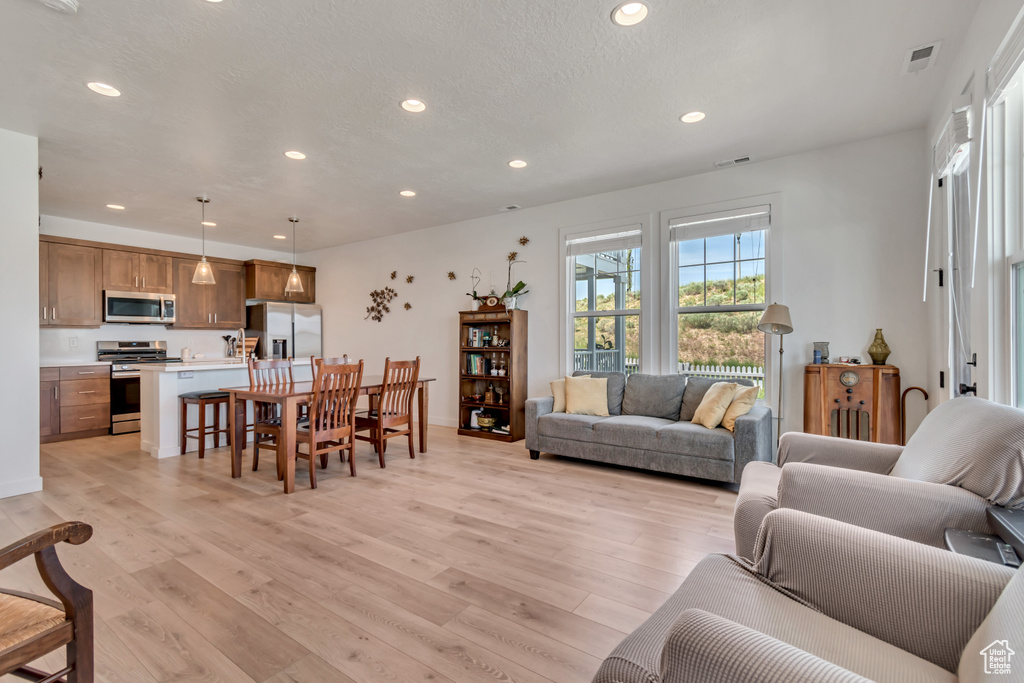 Living room featuring recessed lighting, light wood-style flooring, and baseboards