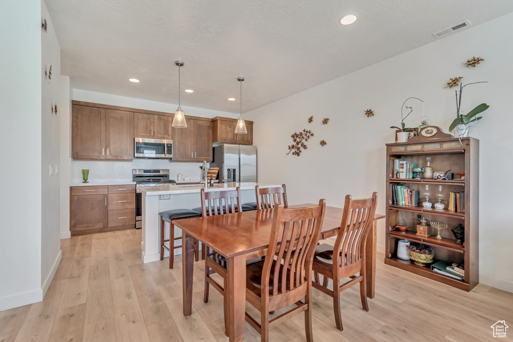 Dining area featuring light wood finished floors, recessed lighting, and baseboards