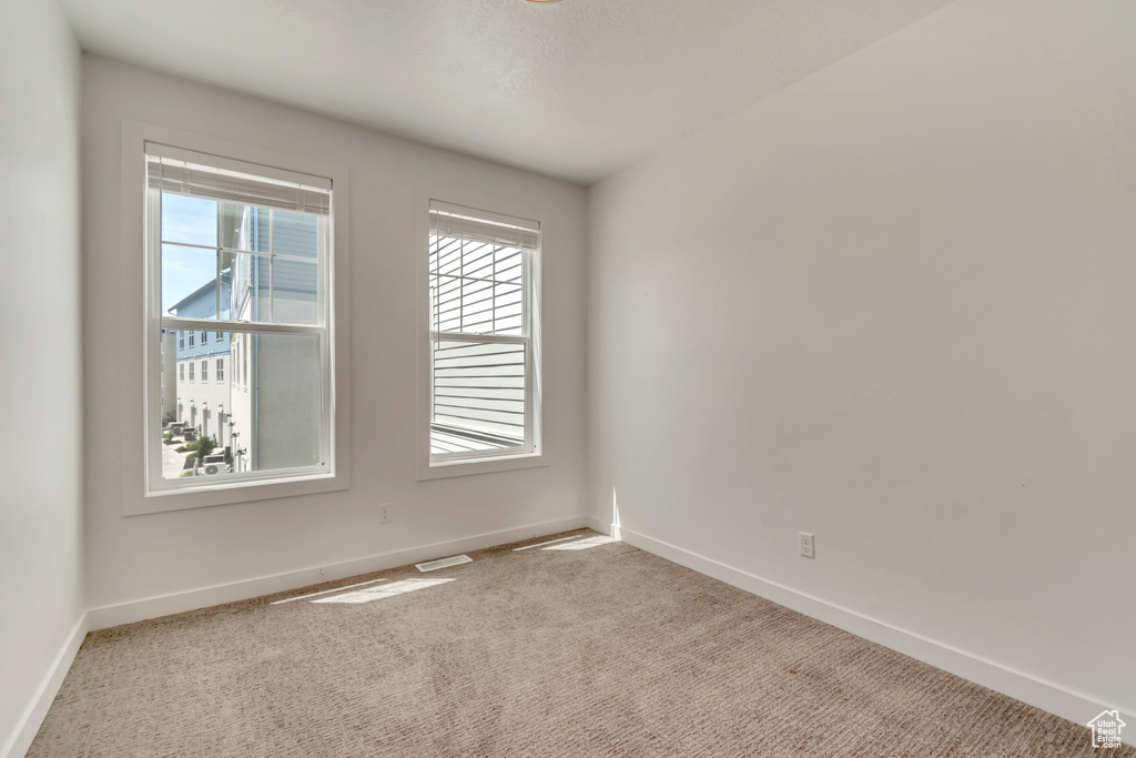 Carpeted empty room with baseboards