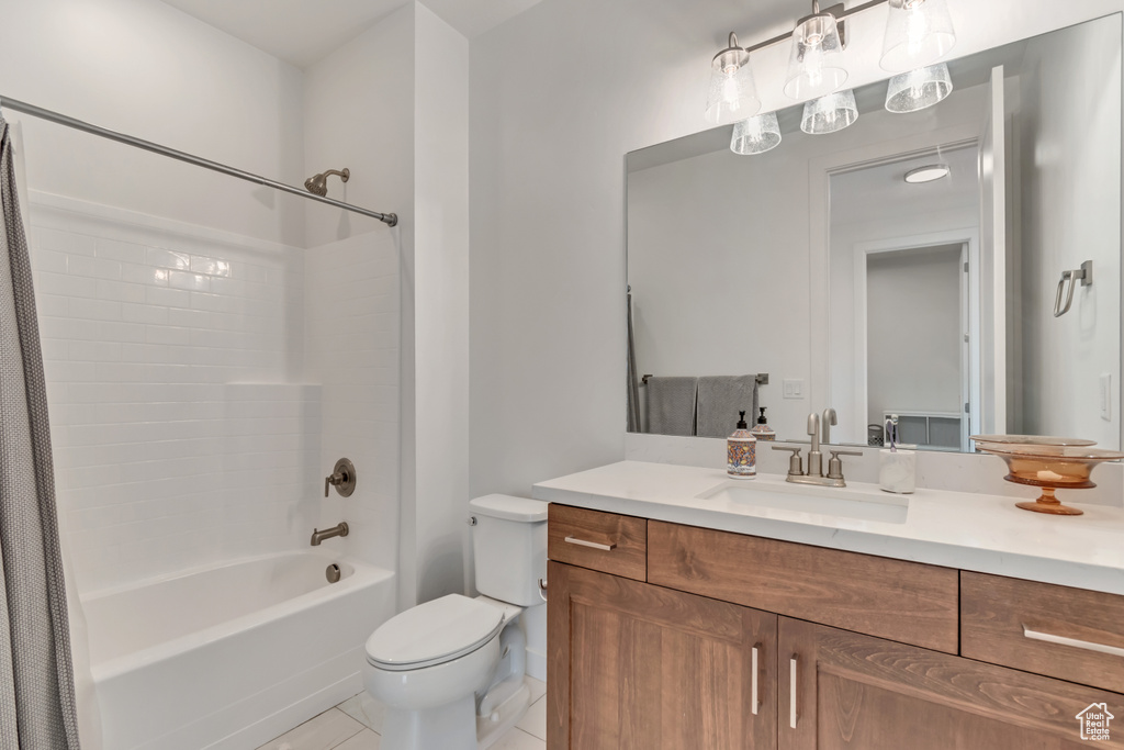 Bathroom with toilet, shower / bathtub combination with curtain, vanity, and tile patterned flooring