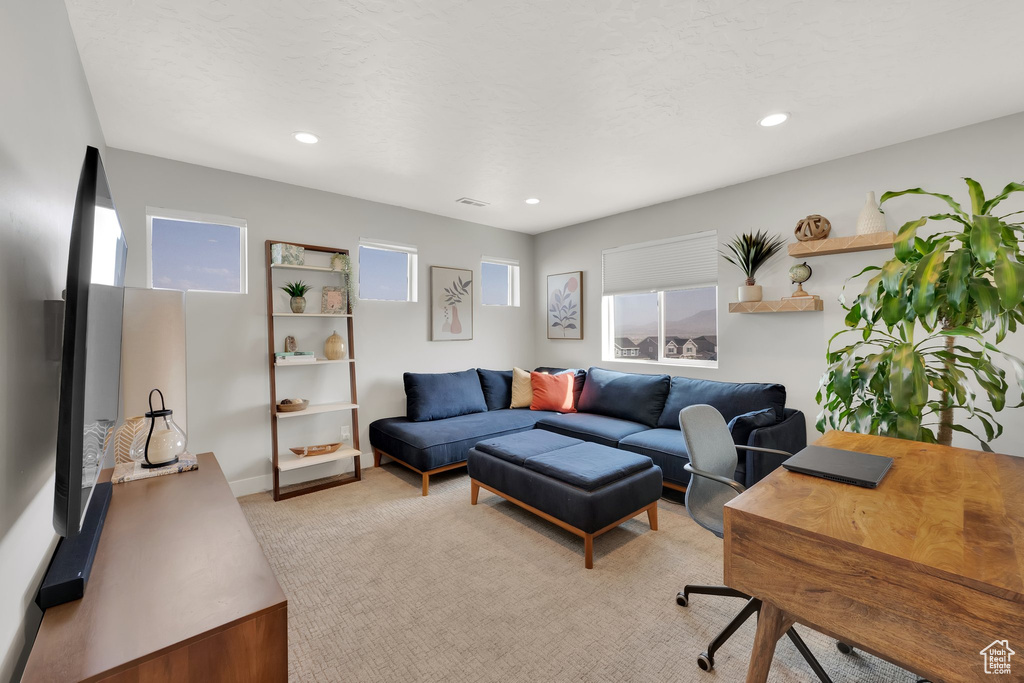 Living room featuring light carpet, a desk, recessed lighting, and baseboards