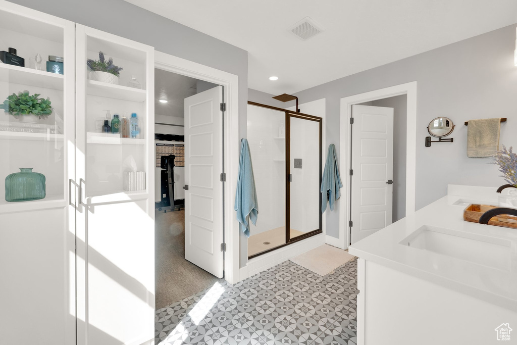 Bathroom with a stall shower, tile patterned floors, recessed lighting, double vanity, and a spacious closet