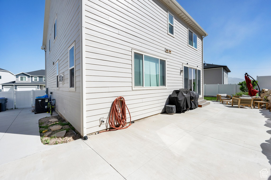 Back of house with an outdoor living space, fence, and a patio