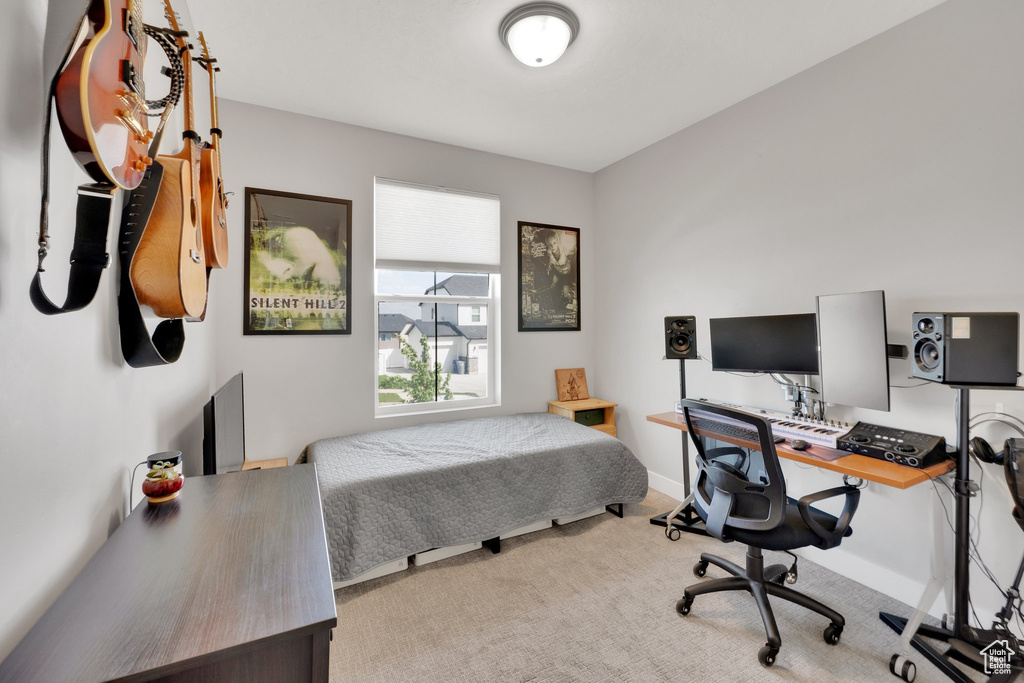 Bedroom with carpet flooring, an office area, and baseboards