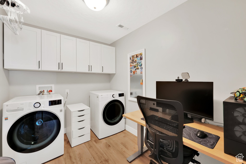 Clothes washing area featuring independent washer and dryer, cabinet space, light wood finished floors, and an office area