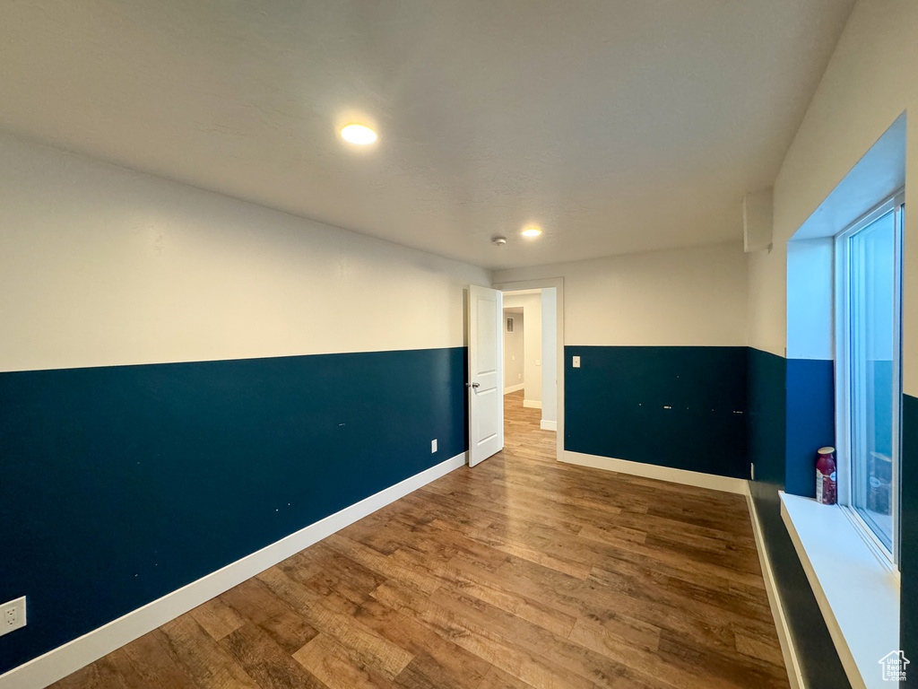 Empty room with wood finished floors, recessed lighting, and baseboards